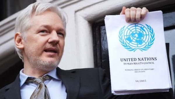  WikiLeaks founder Julian Assange holds a copy of the UN report condemning his 'arbitary detention' as he addresses reporters from the Ecuadorian embassy in London, on February 5, 2016. (AFP/File)