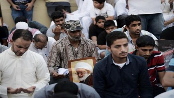 Bahraini protestors hold a placard bearing the portrait of top Bahraini Shia cleric Sheikh Issa Qassim, during a protest against the revocation of Qassim's citizenship near his house in the village of Diraz, west of Manama, on June 20, 2016. (AFP/File)