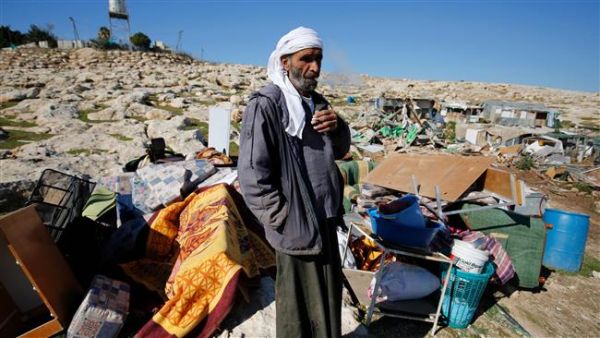 Palestinian Bedouin Abu Nawar stands next to the remains of makeshift homes that were demolished by Israeli forces east of al-Quds (Jerusalem) in the occupied West Bank, on January 6, 2016. (AFP/File)