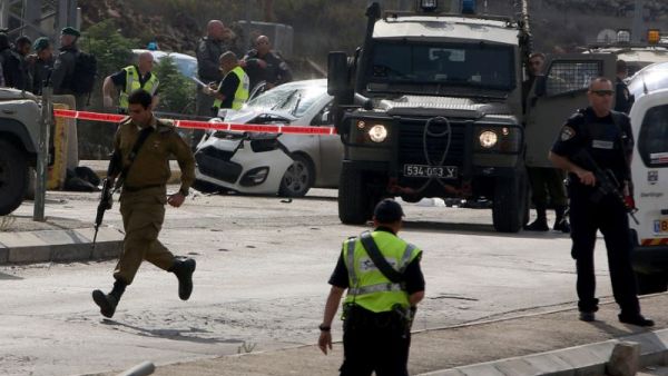 Israeli security forces gather at the scene where a Palestinian man was shot dead by Israeli security forces after ramming his car into a group of Israelis at Tapuah junction, south of Nablus in the West Bank, on November 8, 2015. (AFP/Jaafar Ashtiyeh)