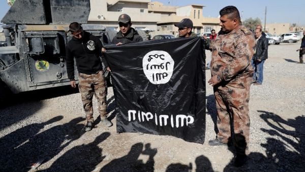 Iraqi army soldiers hold a flag from the Daesh jihadist group up-side-down. (AFP/File)