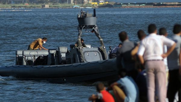 Egyptian rescue workers arrive on a boat carrying bodies of migrants in Rosetta, Egypt, on Friday after a boat carrying migrants capsized in the Mediterranean. (AFP/File)