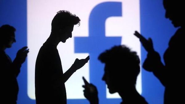 Internet users shadow a Facebook logo backdrop. (Facebook, dawn.com)