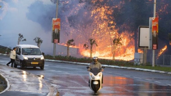 Israelis drive past a fire raging through the northern Israeli port city of Haifa on November 25, 2016. (AFP/File)