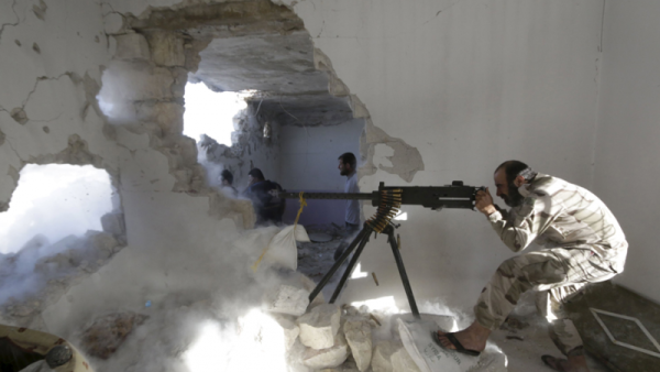 A Free Syrian Army fighter fires a weapon inside a damaged building during clashes with forces from the Syrian regime. (AFP/File)