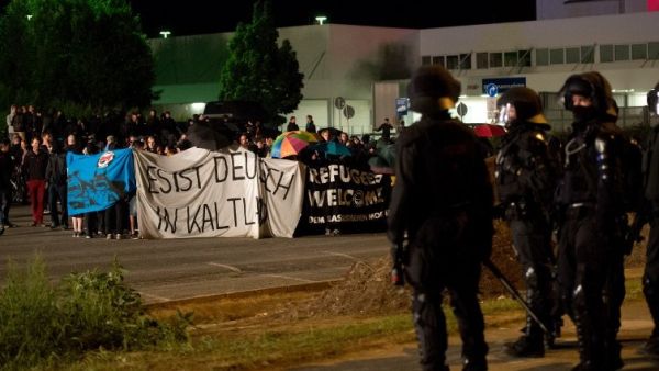 Police face far-right activists protesting the opening of a new center for refugees. (AFP/File)