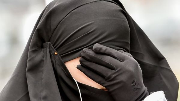 A Muslim woman wearing gloves and a headscarf covers her face in the northern French city of Lille, on June 12, 2015. (AFP/Philippe Huguen)