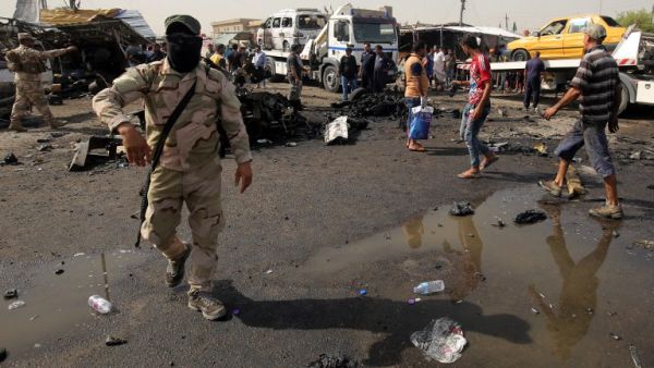Iraqi soldiers and civilians check the damage after a suicide bomber detonated an explosives-rigged vehicle in northern Baghdad's Sadr City, May 17, 2016. (AFP/Ahmad Al-Rubaye)