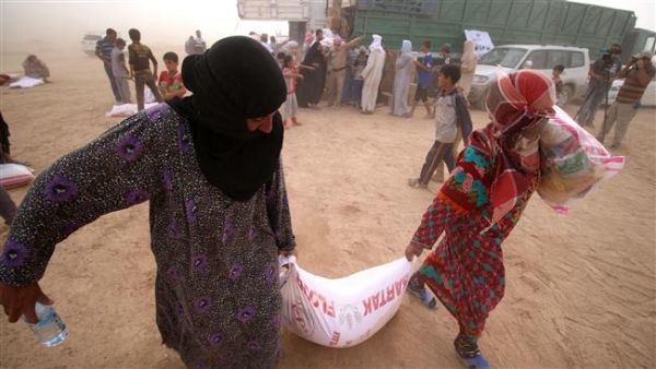 Displaced Iraqis, who fled the western city of Fallujah, carry bags of food donated by a non-government organization called Preemptive Love Coalition at a makeshift camp housing Internally Displaced Persons (IDPs) in the city of al-Khalidiyah. (AFP/File)