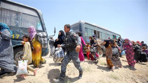 Iraqi forces help families near al-Sejar Village, in Iraq’s Anbar Province, after helping them flee the city of Fallujah, May 27, 2016. (AFP/File)