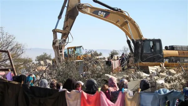 Palestinian family looks on as Israeli authorities demolish home. (Twitter)