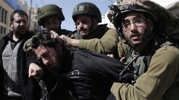 In this file photo, Israeli soldiers violently arrest a Palestinian demonstrator during a protest. (AFP/File)