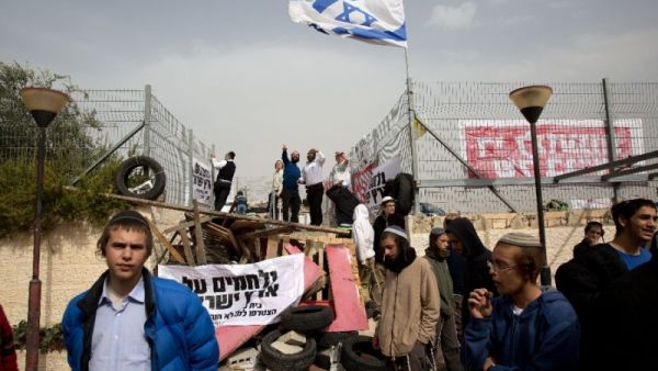 Israeli settlers barricade themselves at a synagogue in the West Bank settlement of Givat Zeev. (AFP/File)
