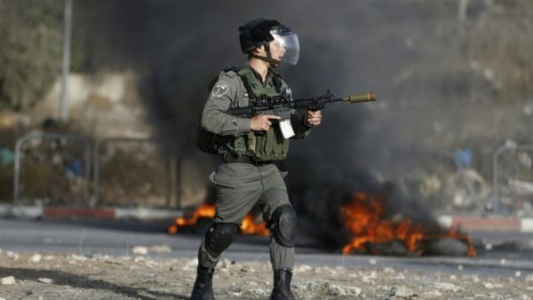 An Israeli border guard holds a rifle with a rubber bullet attachment during clashes with Palestinian youths in the West Bank town of al-Ram, north of Jerusalem, on October 9, 2016. (AFP/Abbas Momani)
