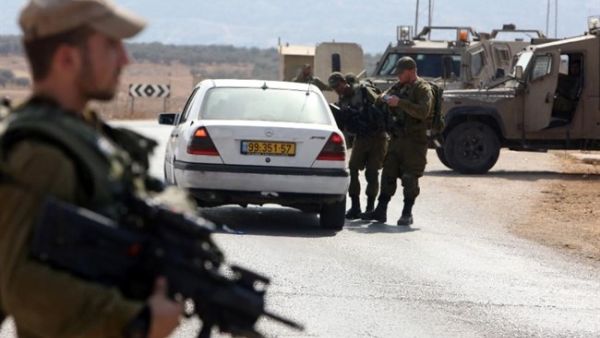 Israeli soldiers inspect a Palestinian car at a checkpoint close to the West Bank village of Beit Furik, east of Nablus, on October 2, 2015. (AFP/Jaafar Ashtiyeh)