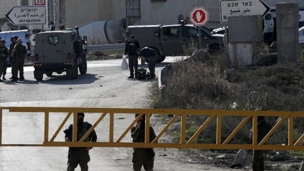 Israeli security forces stand guard at a checkpoint near the West Bank city of Hebron, on Dec. 24, 2015. (AFP/File)