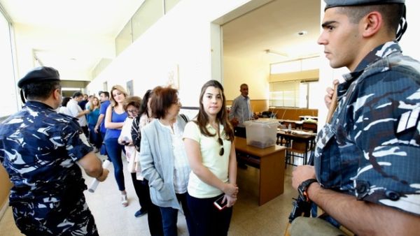 Lebanese security forces stand guard as women stand in line to cast their vote. (AFP/File)