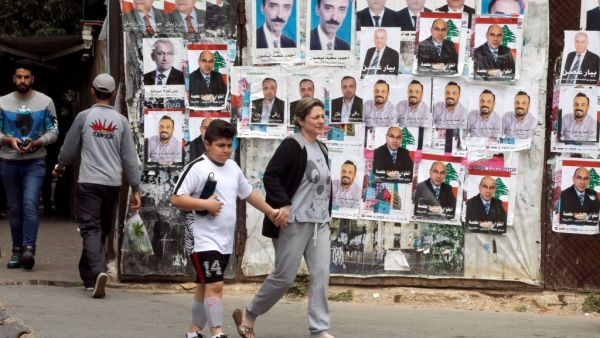 People walk past posters of Lebanese candidates running in the country's municipal election. (AFP/File)