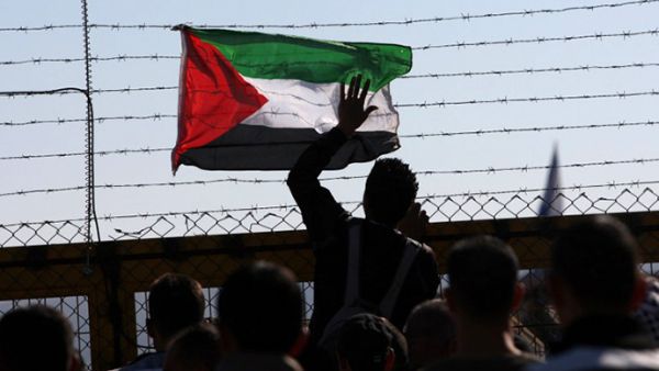 A Palestinian flag is attached to the barbed wires of Israel's Ofer prison in West Bank. (AFP/File)