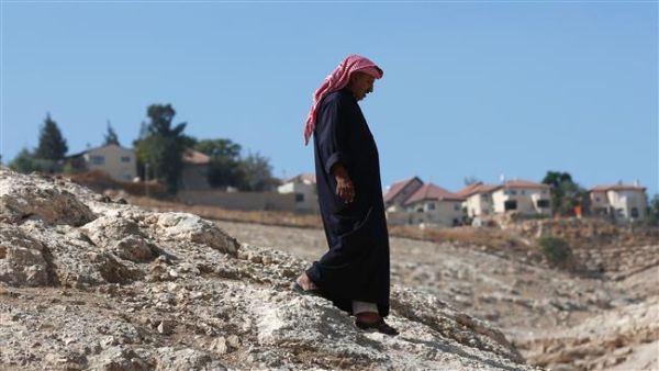 A Palestinian Bedouin walks past the Israeli settlement of Kedar in the Bedouin village of Wadi Abu Hindi, near the town of al-Azariya in the occupied West Bank, October 10, 2016. (AFP/File)