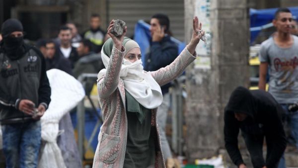 A young woman shows stones during clashes with Israeli forces in Hebron October 7, 2015. (AFP/Hazem Bader) 