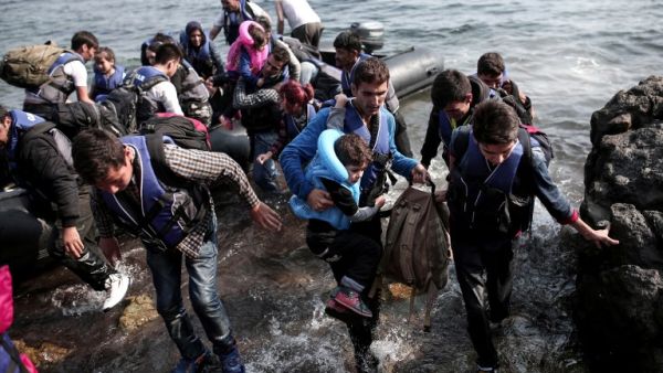 Syrian refugees land on the shores of the Greek island of Lesbos in an inflatable dingy across the Aegean Sea from Turkey, September 3, 2015. (AFP/Angelos Tzortzinis)