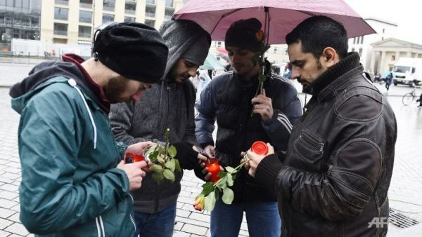 Syrian refugees light candles to place them outside the French embassy to Germany in Berlin on November 15, 2015 for victims of the November 13 attacks in Paris. (AFP Photo/Tobias Schwarz)