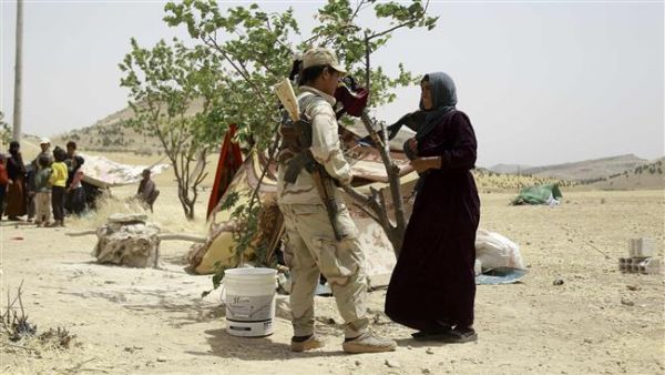 Syrian woman, who fled the assault in Manbij, talks to a Kurdish fighter at an encampment on the outskirts of the town, June 4, 2016. (AFP/File)