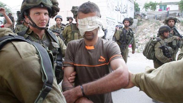 A Palestinian is arrested by Israeli forces on June 21,2014 in the occupied West Bank village of Beit Ola, near the town of Hebron. (AFP/Hazem Bader)
