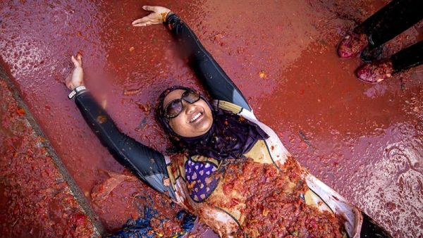 A reveller lies in tomato pulp during the annual "tomatina" festivities in Spanish village. (AFP/File)