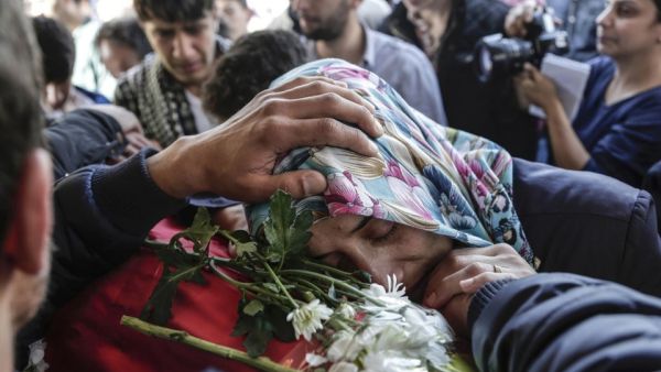 A woman places her head on the coffin of a victim at a funeral in Istanbul Monday, October 12, 2015. (AFP/Yasin Akgul)