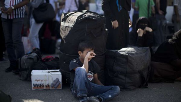 A Palestinian boy waits with his family to cross into Egypt at the Rafah crossing between Egypt and the southern Gaza Strip. (AFP/Mahmud Hams)