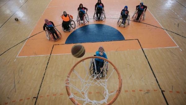 A Palestinian woman takes a shot during a wheelchair basketball coaching session, headed by US coach Jess Markt, in Khan Younis in the southern Gaza strip on May 28, 2016. (AFP/Said Khatib)