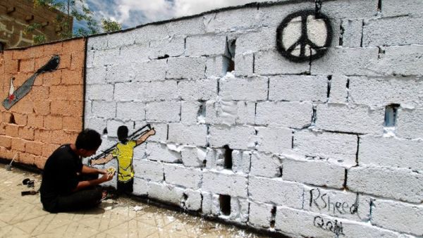 A Yemeni artist sprays graffiti on a wall in the capital Sanaa in support of peace. (AFP/File)