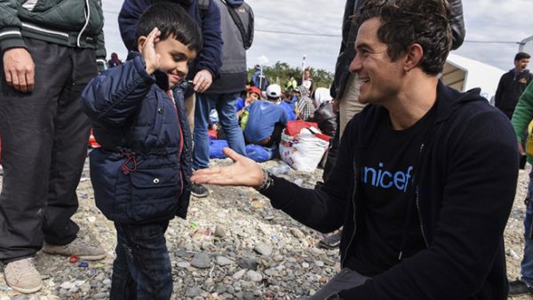 Hollywood actor Orlando Bloom laughs and snaps selfies with children as he visits a Syrian refugee camp in Macedonia. (AFP)