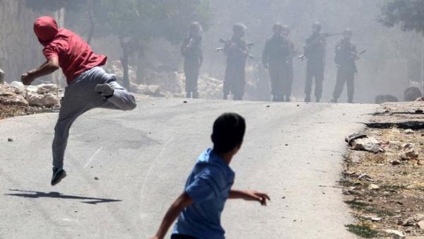 Palestinian protesters throw stones towards Israeli security forces during clashes following a protest against the expropriation of Palestinian land by Israel in the village of Kfar Qaddum near the occupied West Bank city of Nablus (Jaafar Ashtiyeh / AFP)