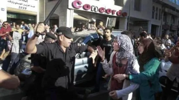 صورة عن الفيسبوك لرجل شرطة يهدد احدى المتظاهرات