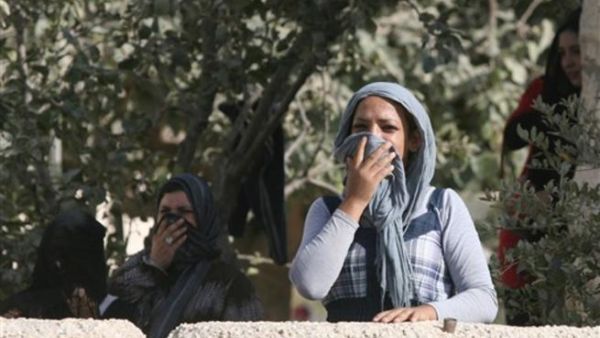 فلسطينيات يغطين انوفهن بسبب كثافة الغاز المسيل للدموع الذي القته قوات الاحتلال على نشطاء يجمعون الزيتون في قرية بيت امر في الخليل/أ.ف.ي