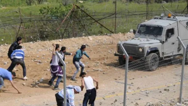 متظاهرون فلسطينيون يرشقون دورية إسرائيلية بالحجارة على حدود الجولان المحتل