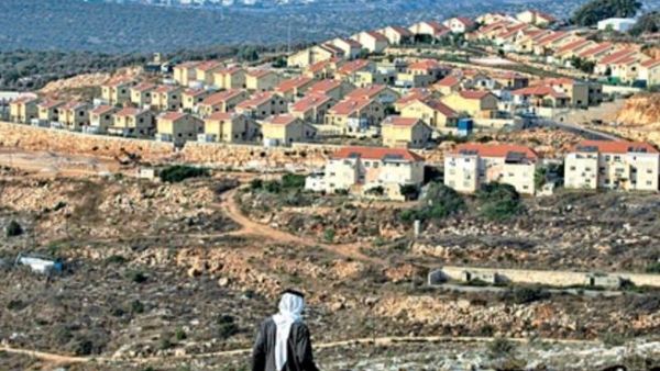 فلسطيني يمر قرب مستوطنة في الضفة الغربية