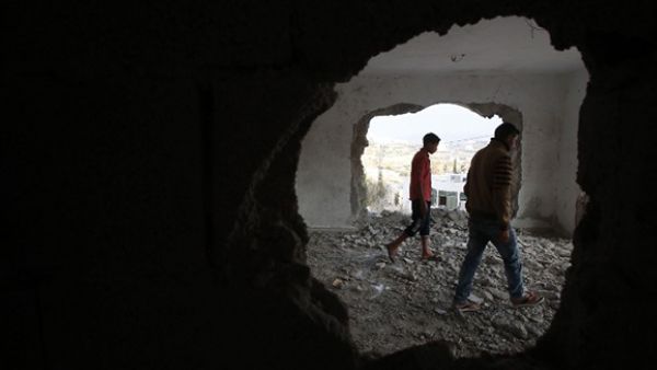 A relative and the brother (R) of late Mohammed Nasser Tarayrah, a Palestinian attacker who stabbed to death an Israeli teen in a Jewish settlement, inspect Tarayrah's home after Israeli army partially destroyed it. (AFP/File)