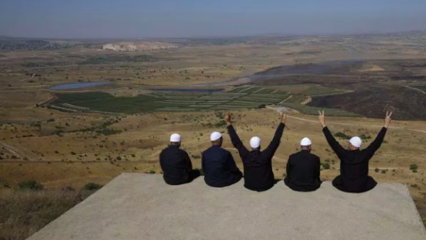 Druze men at the Israeli-annexed Golan Heights flash the V for victory sign as they look out across the southwestern Syrian province of Quneitra on July 7, 2018. (Jalaa Marey/AFP/Getty Images) 