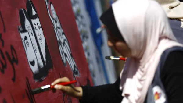 A Palestinian art student paints as she takes part in a festival marking the World Mental Health Day on October 11, 2016 in Gaza City. (AFP/Mohammed Abed)
