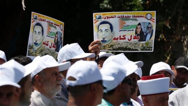 Palestinian protesters hold posters against the administrative detention of Palestinian prisoner Bilal Kayed outside the International Committee of the Red Cross’s offices in East Jerusalem on August 12, 2016. (AFP/File)