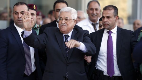 Palestinian president Mahmud Abbas (C) waves as he is escorted out of the Istishari Hospital in the West Bank city of Ramallah on October 6, 2016, following his discharge. (AFP/Abbas Momani)