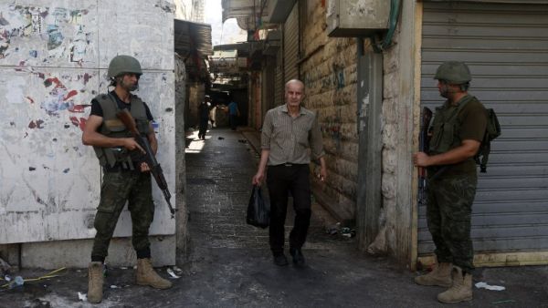 Members of the Palestinian security forces stand guard as they patrol the West Bank city of Nablus on August 23, 2016 during ongoing clashes between Palestinian gunmen and security forces. (AFP/Jaafar Ashtiyeh)