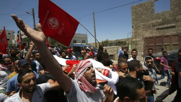 Palestinian mourners carry the body of Aref Jaradat, a 22-year old Palestinian during his funeral in Sair village east of the West Bank city of Hebron on June 20, 2016. (AFP/Hazem Bader)