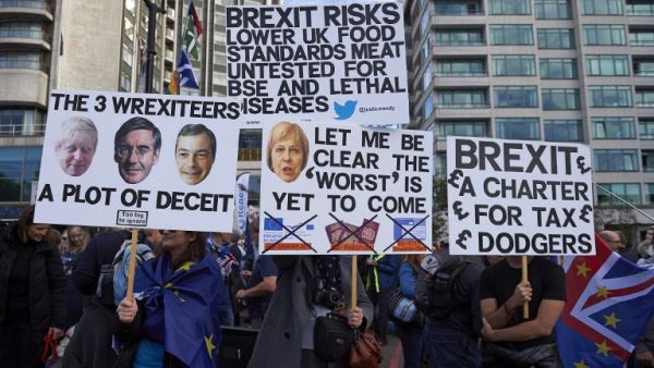 Demonstrators pose for a photograph with their placards at the start of a march calling for a People's Vote on the final Brexit deal, in central London on October 20, 2018. (NIKLAS HALLE'N / AFP)
