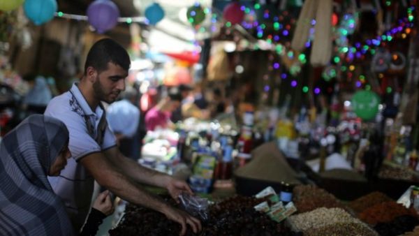 A Palestinian woman buys dates at a market in Gaza City as the faithful prepare for the start of the Muslim holy fasting month of Ramadan on June 17, 2015. (AFP/Mahmoud Hams)