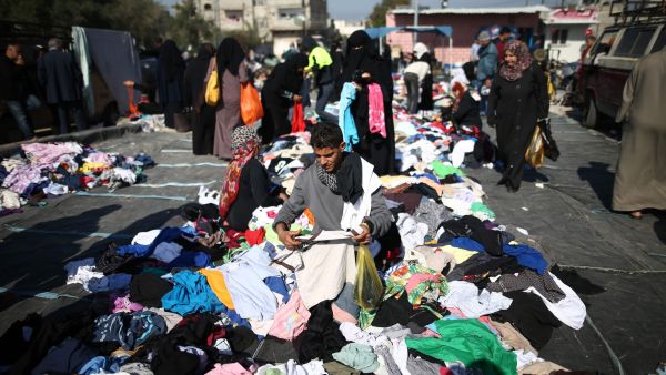 Palestinians sifts through used clothes and items at the weekly flea market in the Nusseirat refugee camp, central Gaza Strip, on February 29, 2016. (AFP)